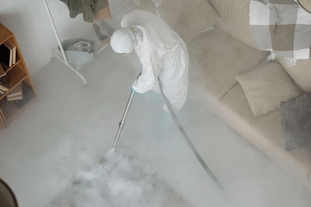 Biohazard cleanup technician in protective equipment, Cotter, AR